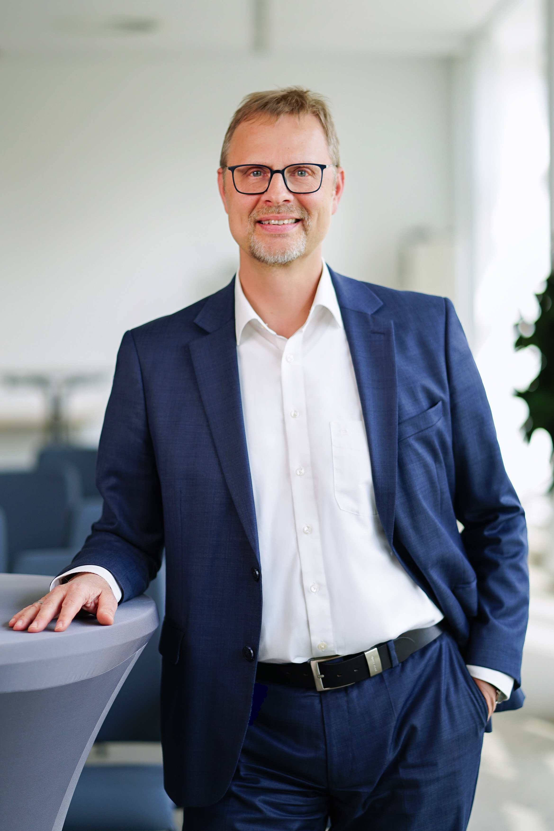 Abteilungsleiter am Stehtisch schaut in die Kamera