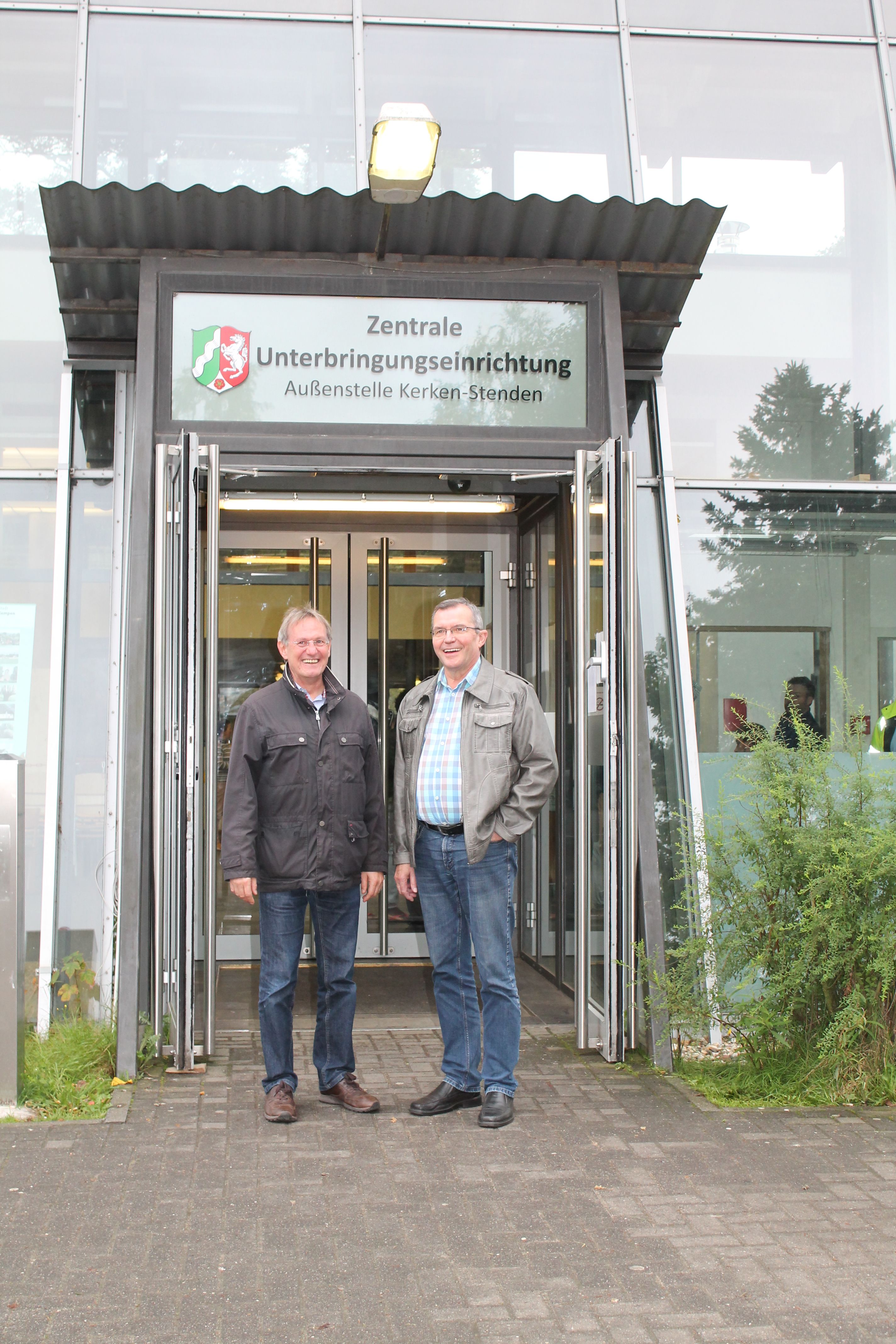 Herr Hüll und Herr Hauke vor dem Eingang der Notunterkunft