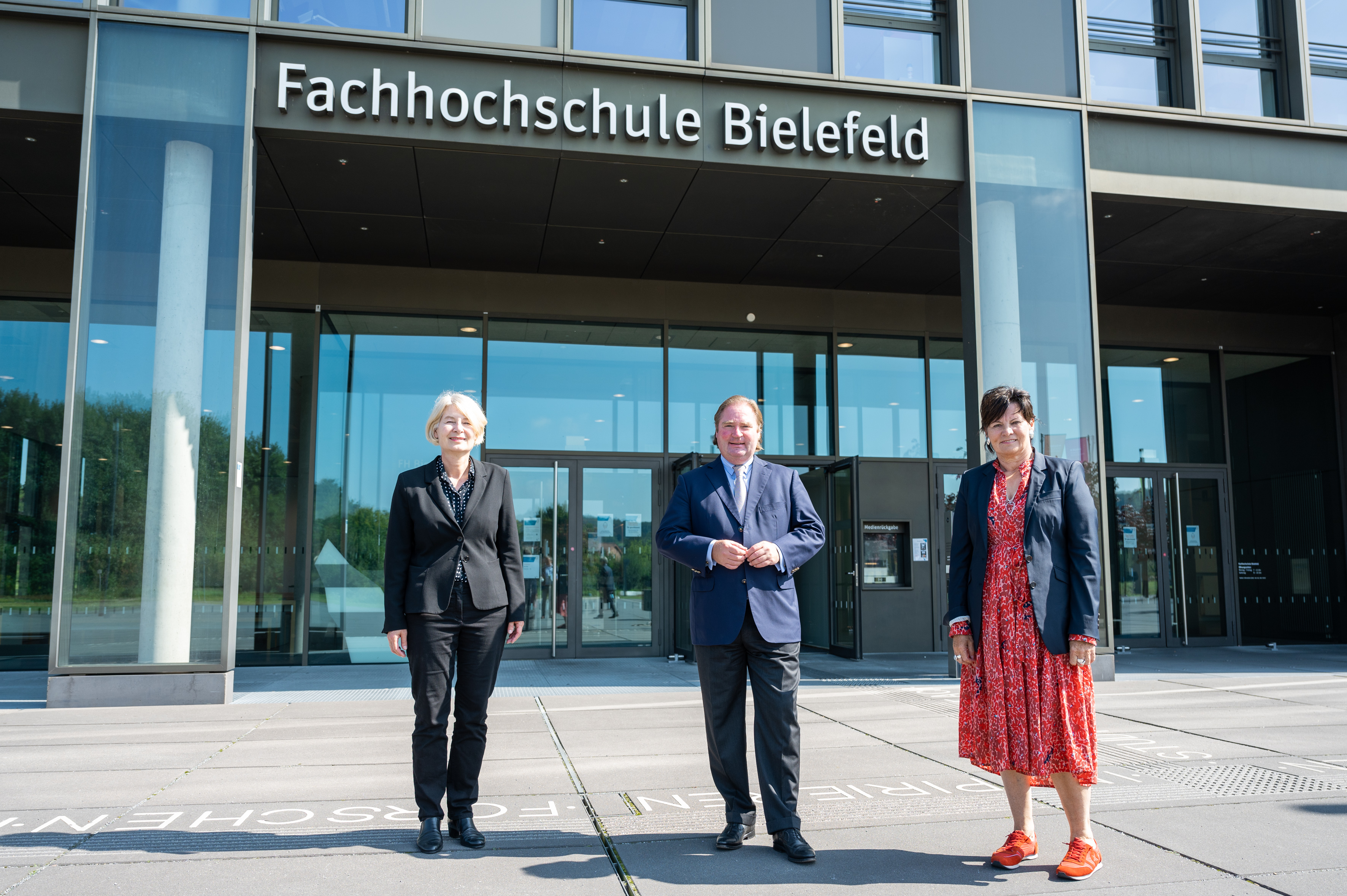 Präsidentin der Fachhochschule Bielefeld Prof. Ingeborg Schramm-Wölk, Minister Lienenkämper und Geschäftsführerin des BLB Gabriele Willems (v.l.) vor der Fachhochschule Bielefeld.