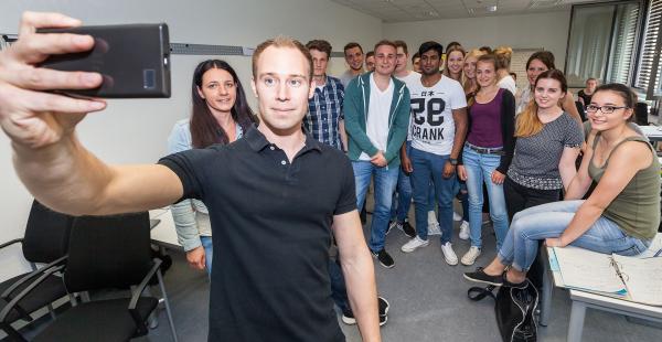Dozent Christoph Dlugos macht ein Selfie mit seinem Lehrsaal
