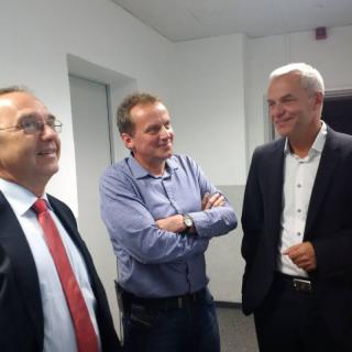 Minister Walter-Borjans wird von Managing Director Christoph Huberty (re.) sowie Michael Nomigkeit über das Betriebsgelände geführt 