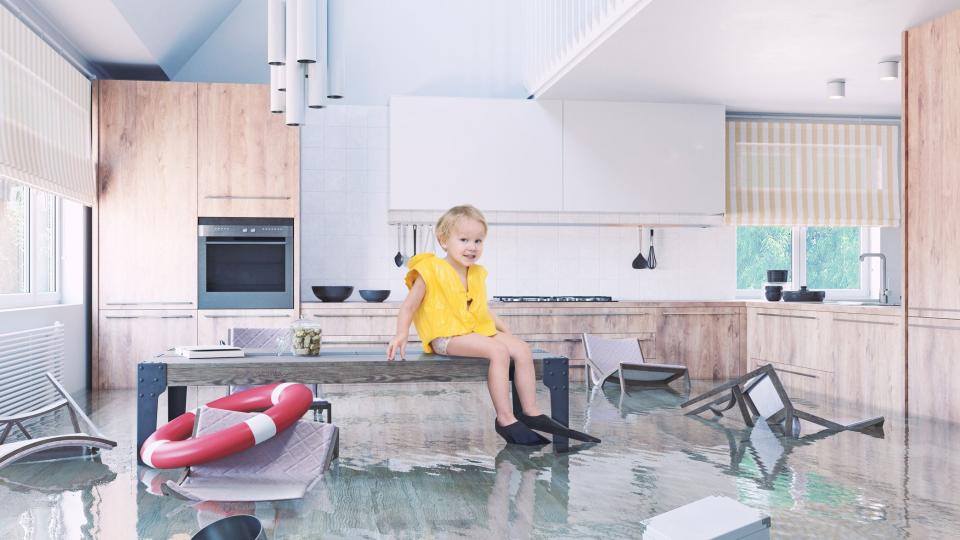 Junge spielt auf dem Tisch, während er in der Küche überflutet
